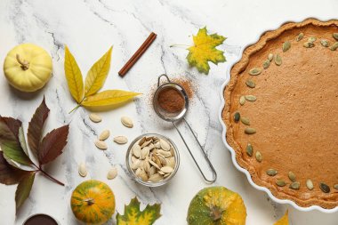 Beyaz mermer arka planda lezzetli balkabağı turtasıyla sonbahar kompozisyonu