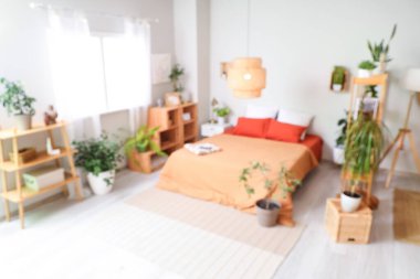 Yeşil bitkiler ve raf üniteleriyle bulanık yatak odası manzarası