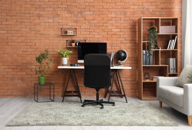 Çalışma odası, raf ünitesi ve kanepe.