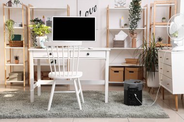 Modern bilgisayarlı rahat çalışma alanı ve çağdaş odada taşınabilir güç istasyonu