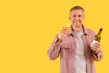 Sarı arka planda şarap kadehi olan olgun bir adam.