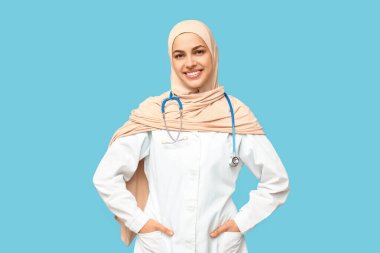 Mavi arka planda steteskoplu kadın Müslüman doktor portresi