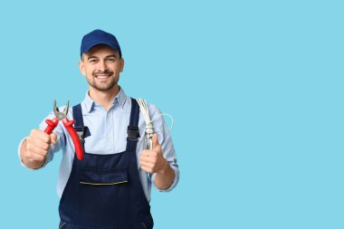 Mavi arka planda pensesi olan erkek elektrikçinin portresi