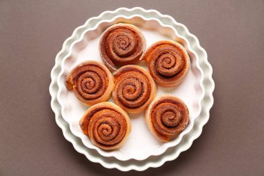 Kahverengi arka planda lezzetli tarçınlı fırın yemekleri.