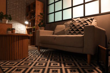 Gri kanepesi, sehpası ve gece lambasıyla modern oturma odasının içinde.