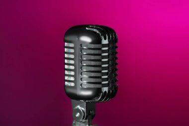 Koyu pembe arkaplandaki Retro mikrofon, yakın plan