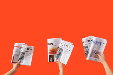 Turuncu arka planda gazeteleri olan kadınlar