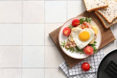Lezzetli kızarmış yumurta, tost, pastırma, domates ve arkaplanda roka.