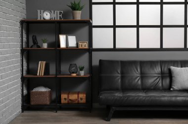 Modern oturma odasının içinde siyah kanepe var.