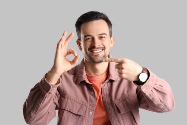 Yakışıklı adam arka planda iyi bir jest yapıyor.