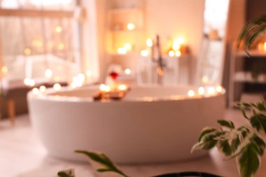 Odasında şarap ve yanan mumlarla dolu küvetin bulanık görüntüsü.