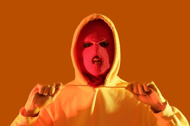 Sarı arka planda kar maskeli yakışıklı bir genç.