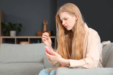 Saç dökülmesi ve evde fırça sorunu olan genç bir kadın.