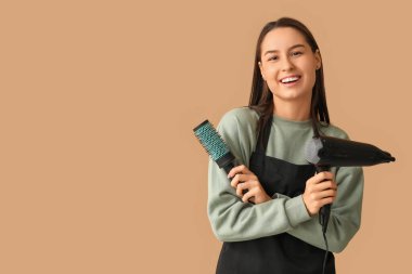 Kurutuculu ve kahverengi arka planda fırçası olan kadın kuaför.