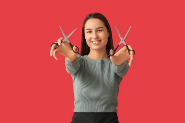 Kırmızı arka planda makaslı kadın kuaför