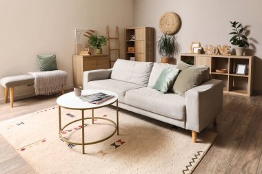 Gri kanepesi ve kahve masası olan modern oturma odasının içinde.