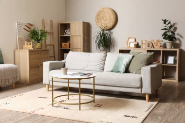 Gri kanepesi ve kahve masası olan modern oturma odasının içinde.