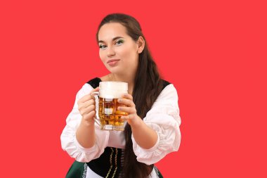 Kırmızı arka planda bir kupa birası olan genç İrlandalı kadın. Aziz Patrick Günü kutlaması