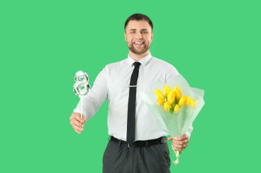 Yeşil arka planda çiçek buketi ve şekil 8 şeklinde balon olan yakışıklı bir adam. Uluslararası Kadınlar Günü kutlamaları