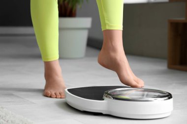Genç bir kadın ağırlığını evde ölçecek. Diyet kavramı