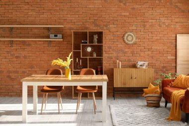 Masası, sandalyeleri ve raf ünitesi olan rahat bir oturma odası.