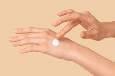 Renkli arka planda doğal kremi olan kadın elleri, yakın plan