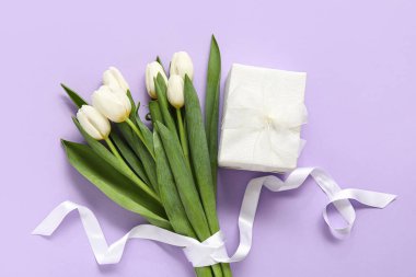 Leylak arkaplanda hediye kutusu olan beyaz laleler.