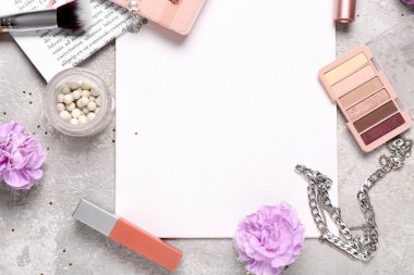 Gri grunge arka planda makyaj ürünleri, çiçekler ve aksesuarlar içeren boş kart