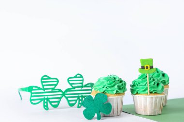 Aziz Patrick Günü için arkaplanda yonca ve gözlüklü lezzetli kekler.