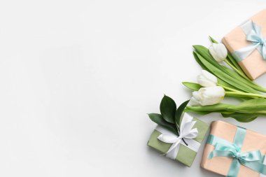 Güzel laleli hediye kutuları ve beyaz arka planda yapraklar. Uluslararası Kadınlar Günü
