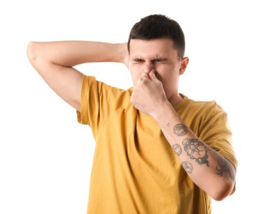 Yakışıklı genç adam beyaz arka planda koltukaltından kötü kokular alıyor.