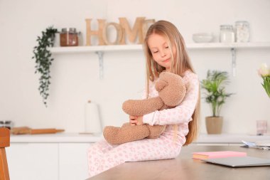 Mutfakta oyuncak ayısı olan sevimli küçük bir kız.