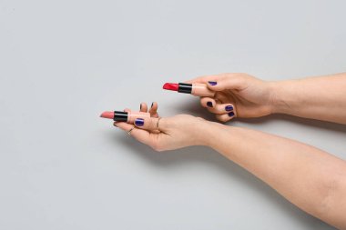 Gri arkaplanda ruj izi olan kadın elleri.