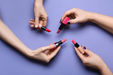 Mor arka planda ruj izi olan kadın elleri.