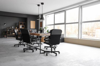 Penceresi, masası ve koltukları olan modern konferans salonu.