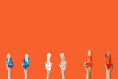 Turuncu arka planda şık ayakkabılı kadınlar