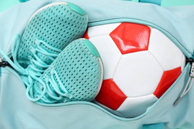 Futbol toplu spor çantası ve arka planda ayakkabılar, yakın plan.