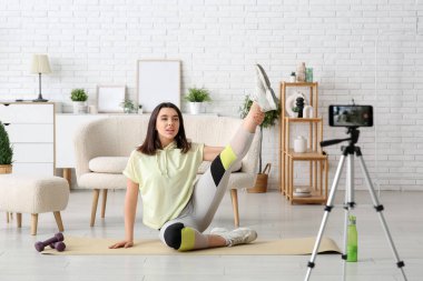 Evde video kaydedilirken kadın spor blogcusu eğitimi