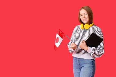 Kırmızı arka planda Kanada bayrağı ve defteri olan kız öğrenci.