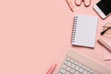 Pembe arka planda defter, kalem ve klavye ile kompozisyon. Üst görünüm