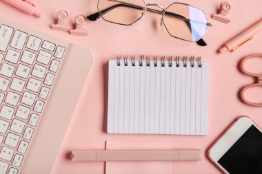 Gözlüklü kompozisyon, pembe arka planda defter ve kalem. Üst görünüm