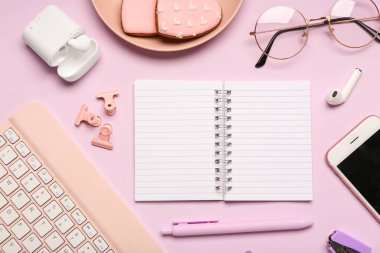 Leylak arka planında defter, gözlük ve klavye olan kompozisyon. Üst görünüm