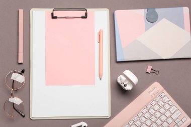 Gri arka planda pano, kulaklık ve klavye ile kompozisyon. Üst görünüm