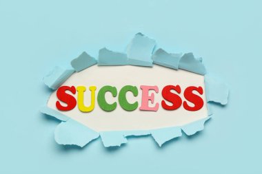 Sözcükler mavi arka plandaki yırtık kağıtlardan anlaşılıyor. Üst görünüm