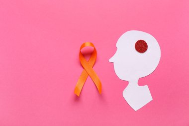 Kağıt insan kafası ve pembe arka planda turuncu kurdele. Çoklu Skleroz Farkındalık Ayı