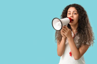 Genç ve güzel afro-amerikan bayan cankurtaran mavi arka planda megafonla