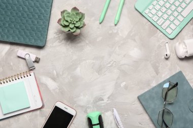 Grunge arka planında bilgisayar klavyesi, not defteri, telefon, kırtasiye ve ev bitkisinden yapılmış çerçeve