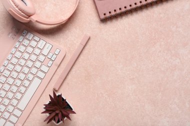 Not defteri, bilgisayar klavyesi ve bej arka planda kulaklık.