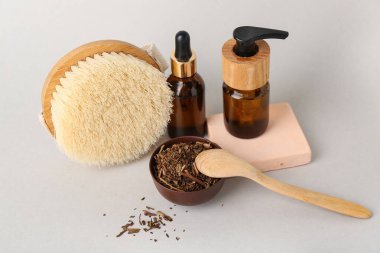 Doğal kozmetik ürünleri, vücut masajı fırçası ve beyaz, yakın plan kurutulmuş otlarla güzel bir kompozisyon.