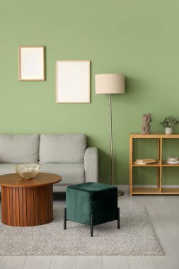 Gri kanepe, puf ve sehpası olan modern bir oturma odası.